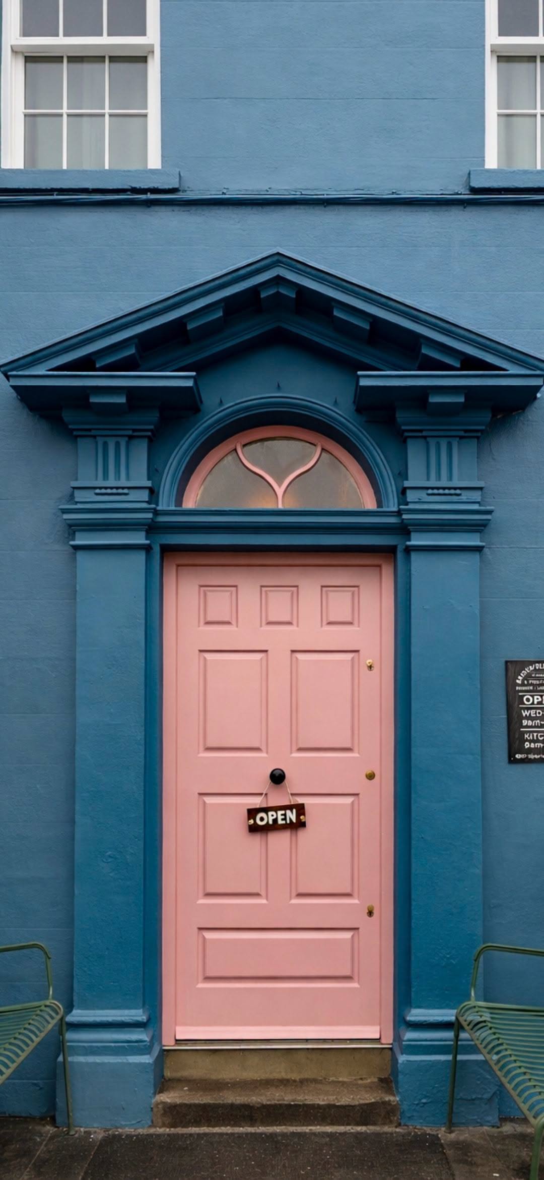 The pink front door of Bridewell Coffee with an open sign